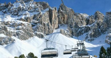 Jazda na nartach w Dolomitach, kabiny dla narciarzy nad horyzontem na tle góry
