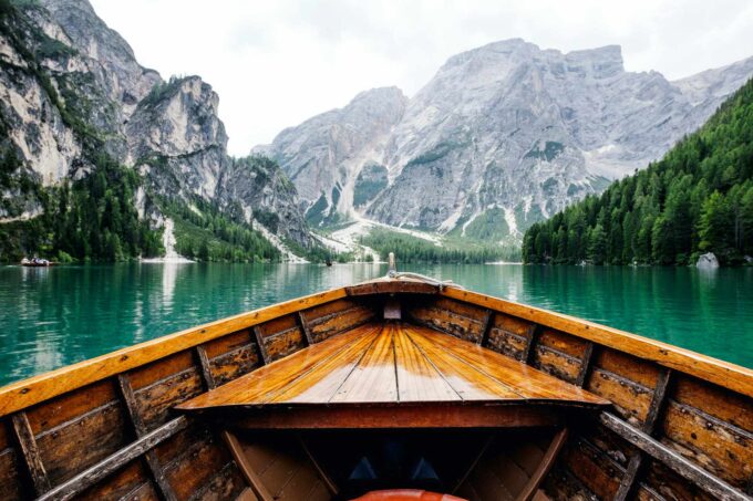 brązowa drewniana łódź płynąca w kierunku góry