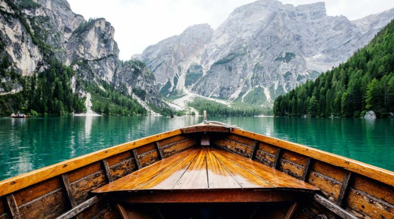 brązowa drewniana łódź płynąca w kierunku góry