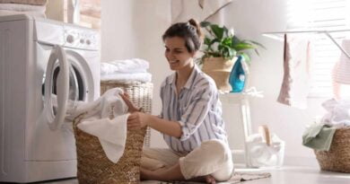 Młoda kobieta wyjmująca pranie z pralki w domu
