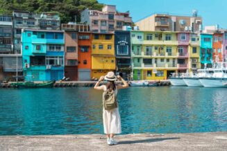kobieta podróżująca po Tajwanie, turysta z plecakiem i kapeluszem zwiedzający Keelung, kolorowy port rybacki Zhengbin
